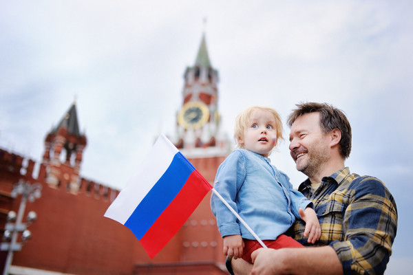 Man holding a baby and Russian flag near the Kremlin