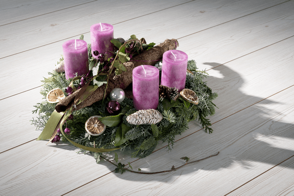 Advent wreath made of evergreen branchlets with purple candles
